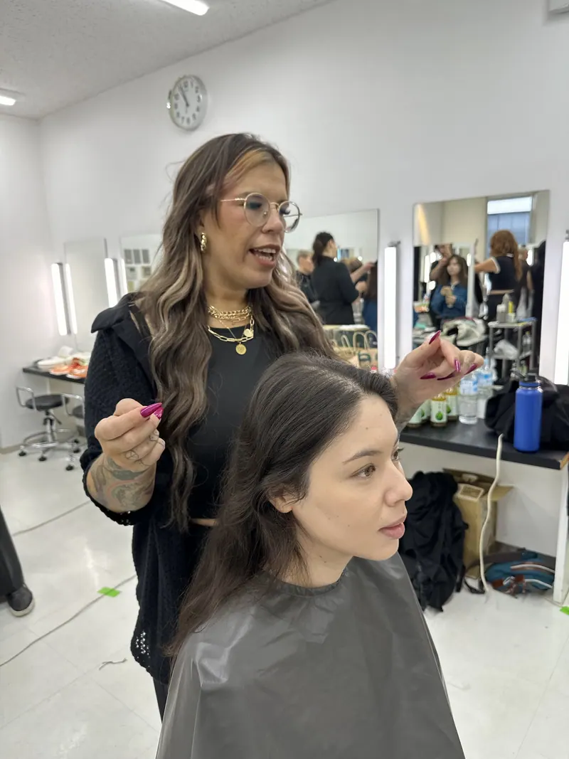 An educator guiding a stylist through a hands-on look