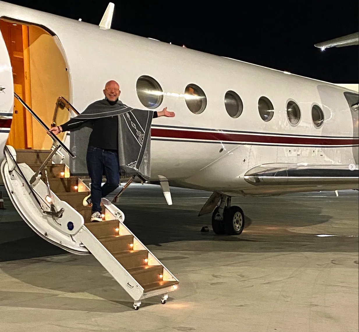Aubrey waving from the steps of a private jet