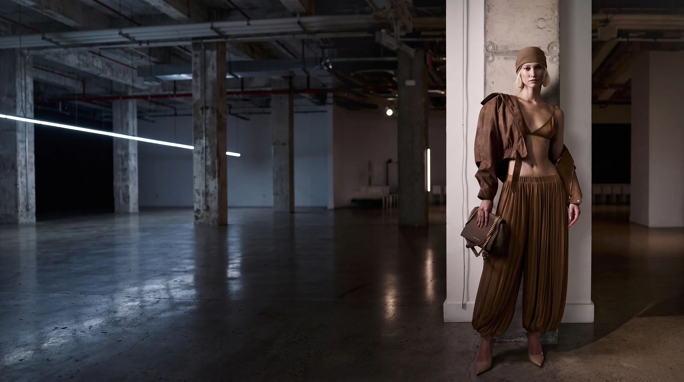 A model in a camel look standing in a New York loft space